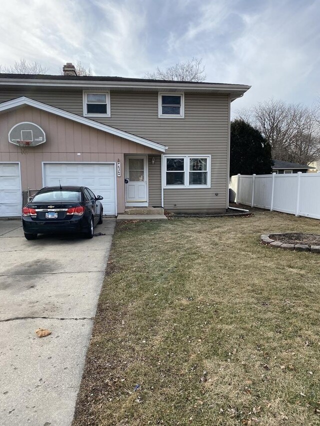 front of property with a garage and a front lawn