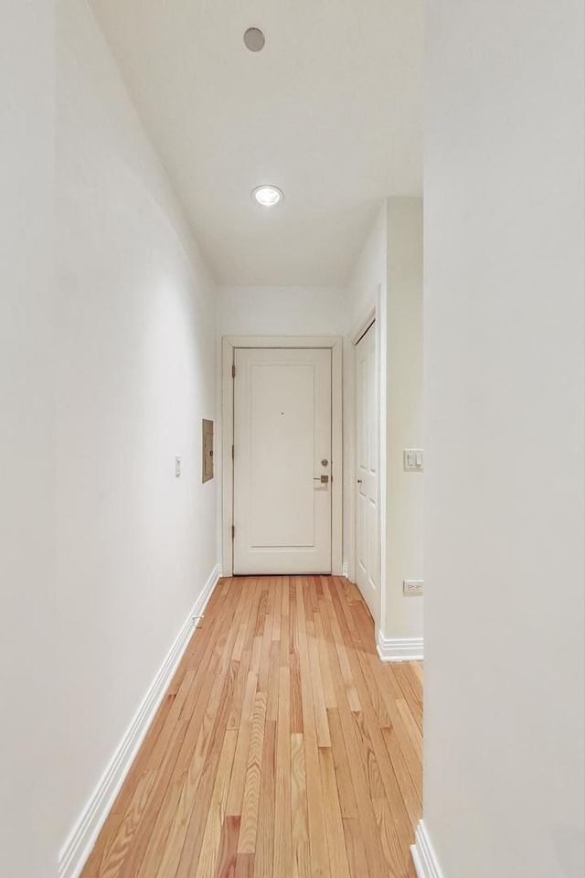 corridor with baseboards and light wood-style floors