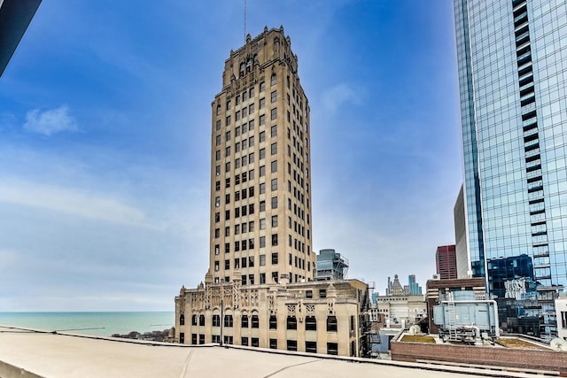 view of building exterior featuring a water view and a view of city