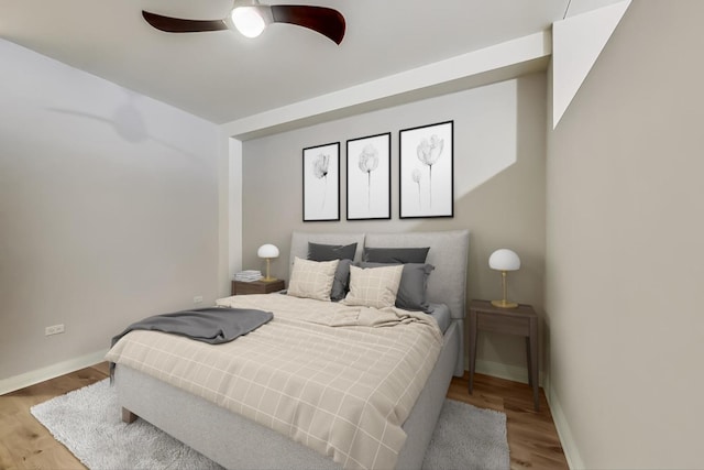 bedroom with wood finished floors, a ceiling fan, and baseboards