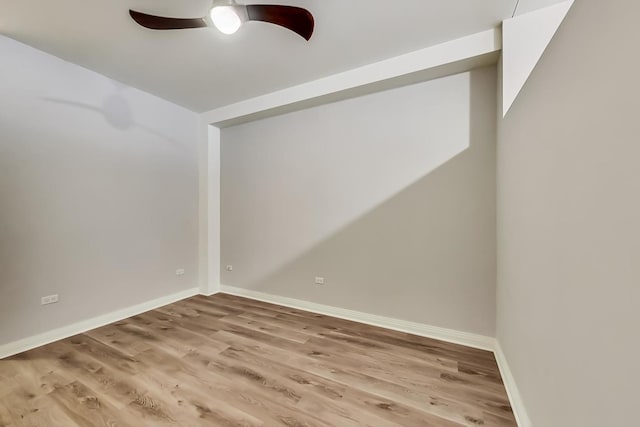 spare room featuring light wood-style floors, baseboards, and a ceiling fan