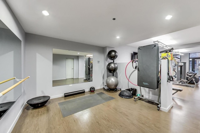 workout area featuring recessed lighting, baseboards, and wood finished floors