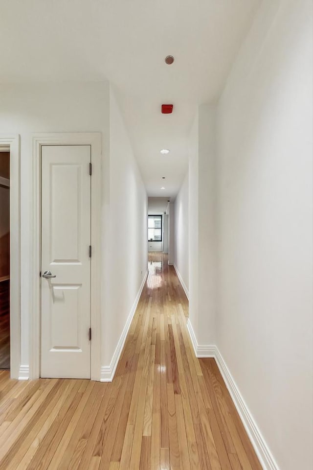 hall featuring light wood-style floors and baseboards