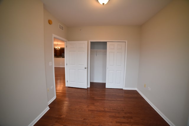 unfurnished bedroom with dark hardwood / wood-style flooring and a closet