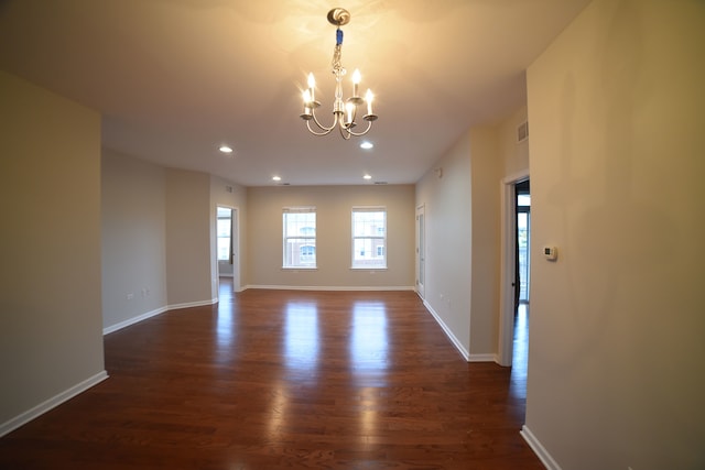 empty room featuring dark hardwood / wood-style flooring and a chandelier