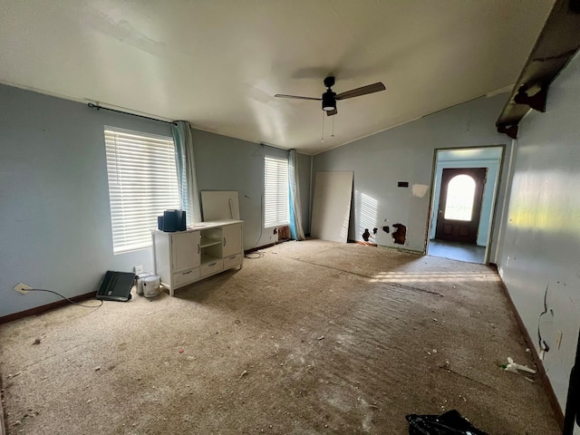 unfurnished living room with vaulted ceiling, carpet flooring, and ceiling fan