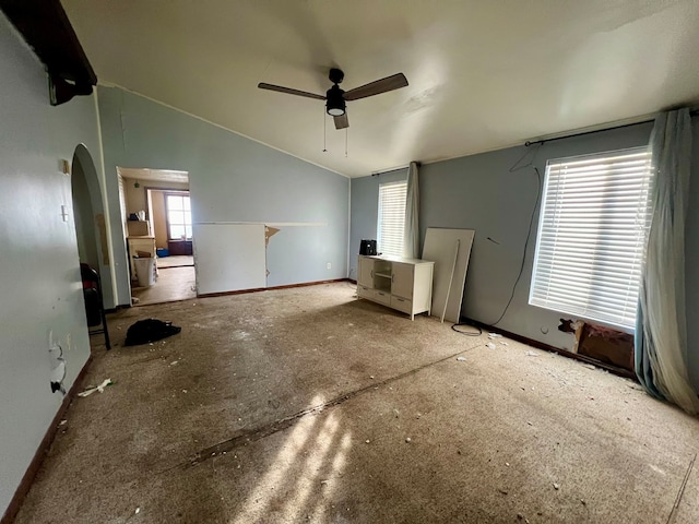 interior space featuring multiple windows, ceiling fan, and vaulted ceiling