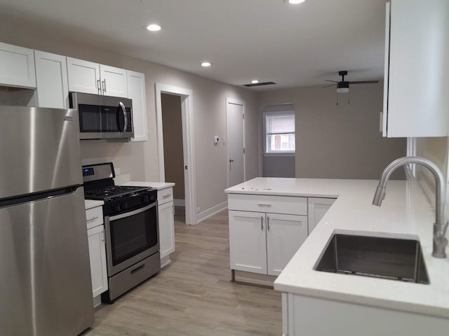 kitchen with light hardwood / wood-style flooring, appliances with stainless steel finishes, sink, and white cabinets