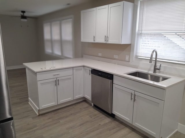 kitchen with white cabinetry, sink, kitchen peninsula, stainless steel dishwasher, and light hardwood / wood-style flooring