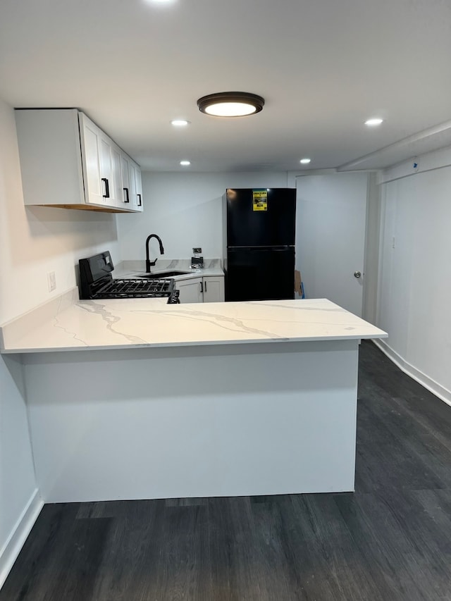 kitchen with white cabinets, dark hardwood / wood-style floors, black appliances, and kitchen peninsula