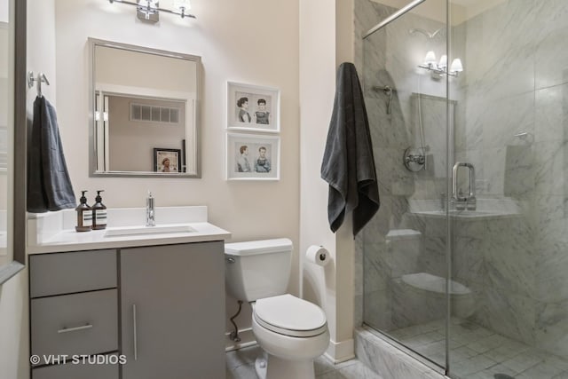 bathroom with vanity, a shower with door, and toilet