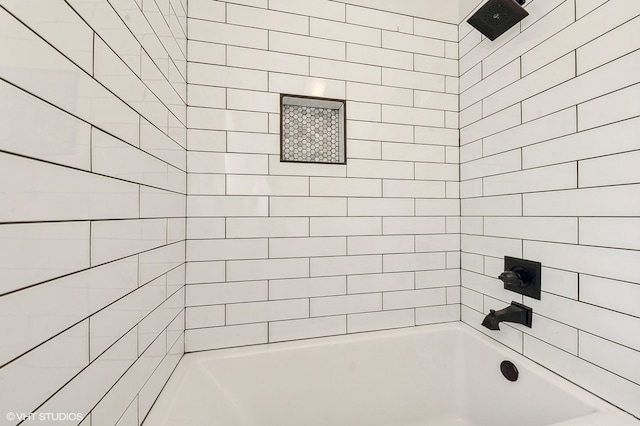 bathroom featuring tiled shower / bath