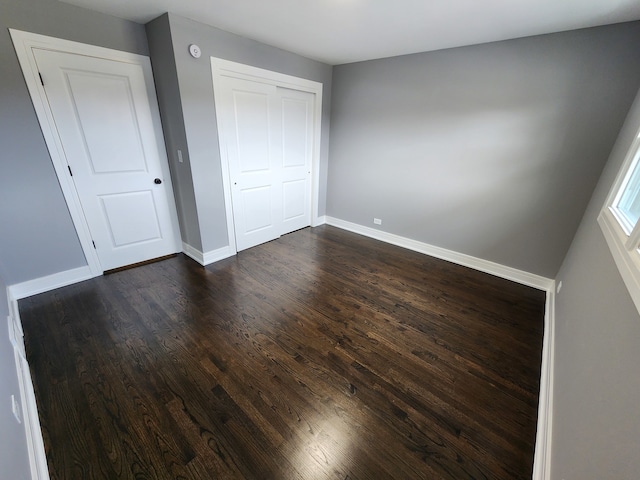 unfurnished bedroom featuring a closet and dark hardwood / wood-style floors