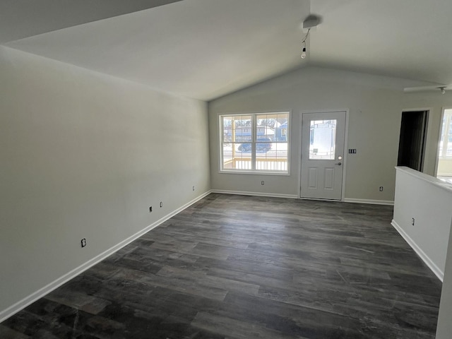 unfurnished living room featuring lofted ceiling, dark wood finished floors, and baseboards