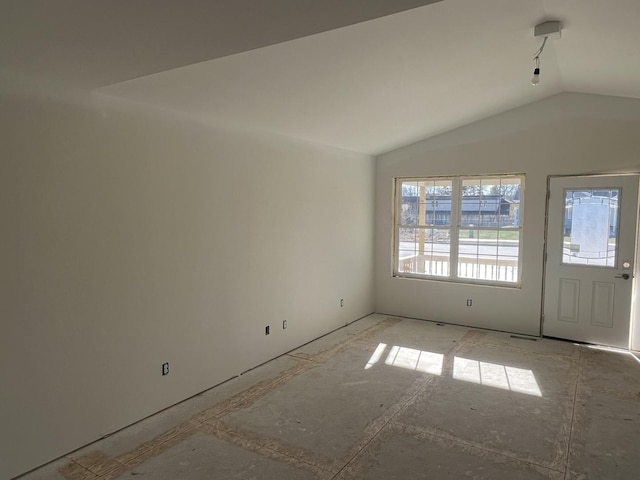 unfurnished room with vaulted ceiling