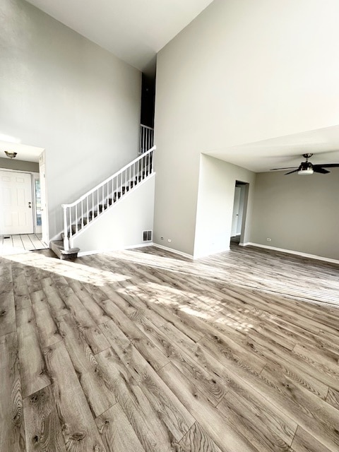 unfurnished living room with ceiling fan and wood-type flooring