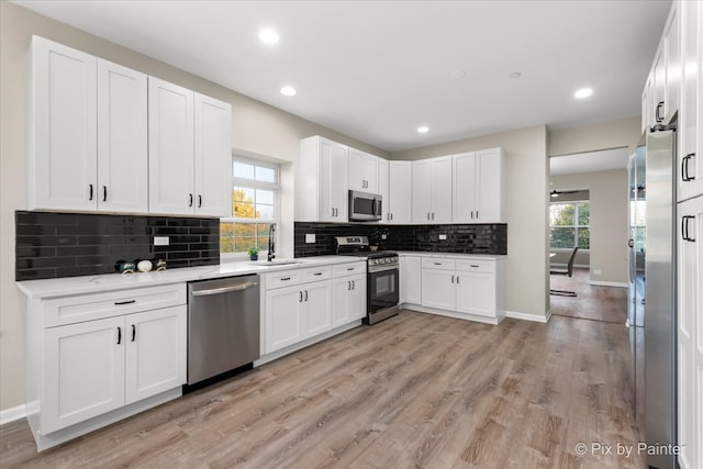 kitchen featuring white cabinetry, light wood-type flooring, appliances with stainless steel finishes, and plenty of natural light