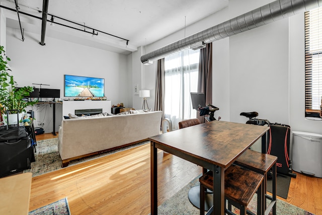 dining space with a wealth of natural light, wood-type flooring, and track lighting