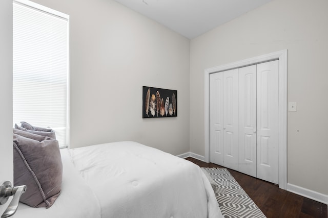 bedroom with dark hardwood / wood-style floors and a closet