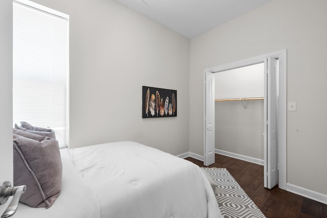 bedroom with dark hardwood / wood-style flooring and a closet