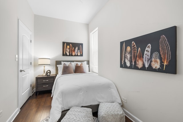 bedroom featuring dark hardwood / wood-style flooring and vaulted ceiling