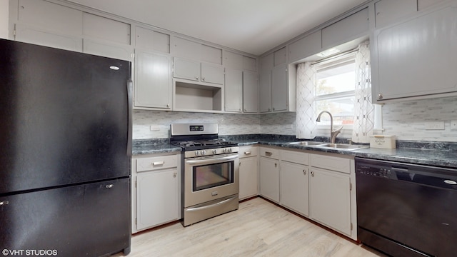 kitchen with sink, black appliances, backsplash, light hardwood / wood-style flooring, and white cabinets