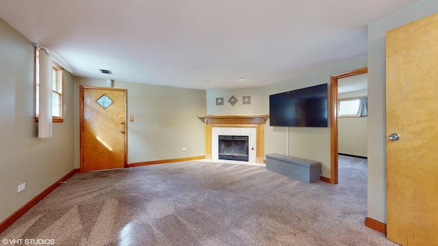 unfurnished living room with carpet and a tile fireplace