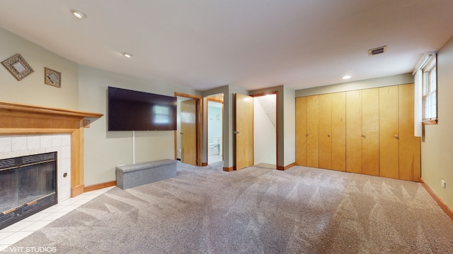 unfurnished living room featuring light colored carpet and a tile fireplace