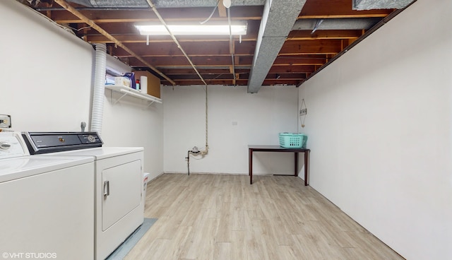 clothes washing area featuring separate washer and dryer and light hardwood / wood-style flooring