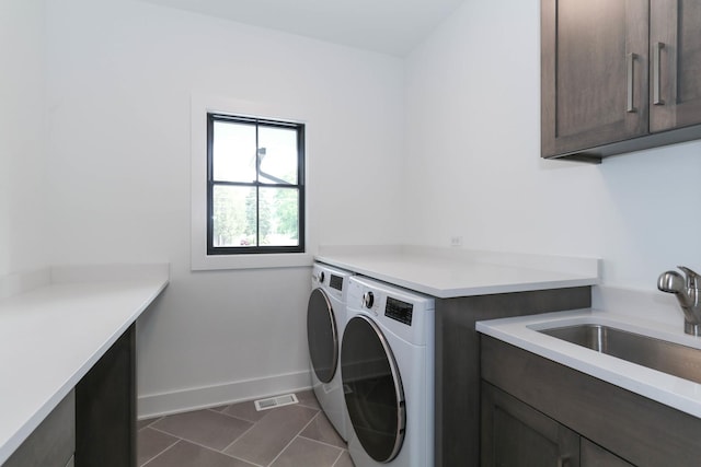 26327 Baxter Dr, Plainfield, IL 60544 - laundry room featuring washer and dryer, cabinet space, dark tile patterned floors, and baseboards