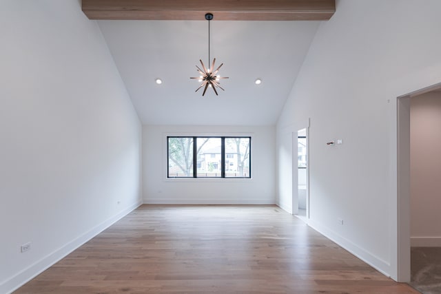 unfurnished living room featuring wood-type flooring, beamed ceiling, high vaulted ceiling, and a notable chandelier