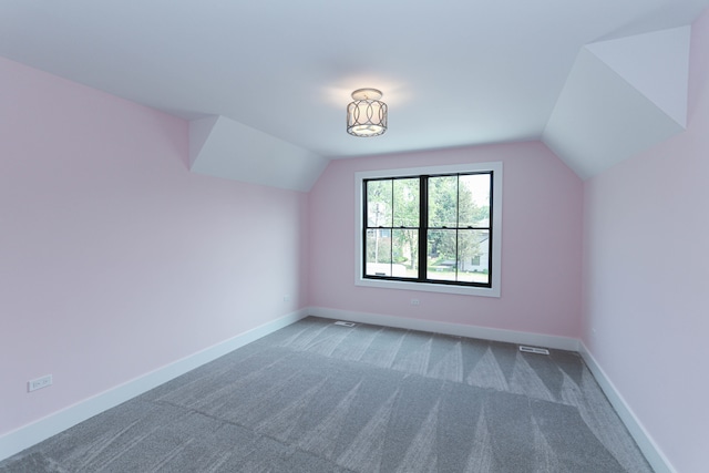 bonus room with carpet flooring and vaulted ceiling