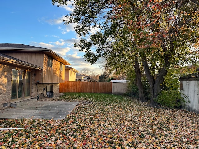 view of yard featuring central AC, a patio area, and a shed