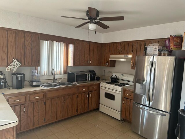 kitchen featuring ceiling fan, stainless steel appliances, and sink