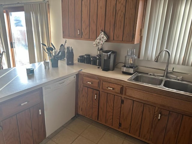 kitchen with dishwasher, sink, and light tile patterned floors