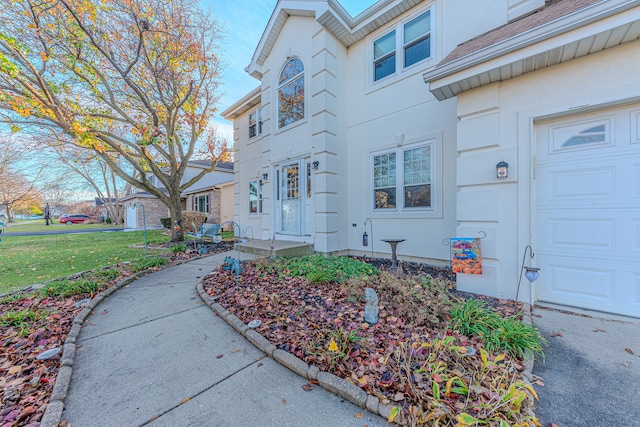 entrance to property with a lawn and a garage