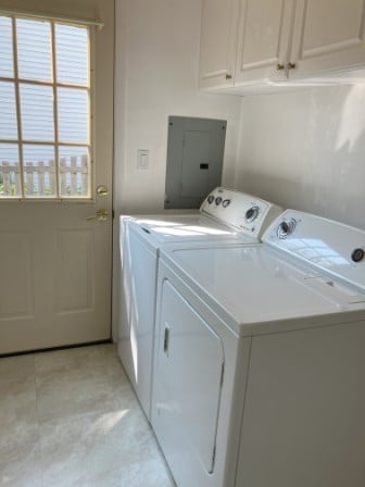 washroom featuring electric panel, cabinets, and washing machine and clothes dryer