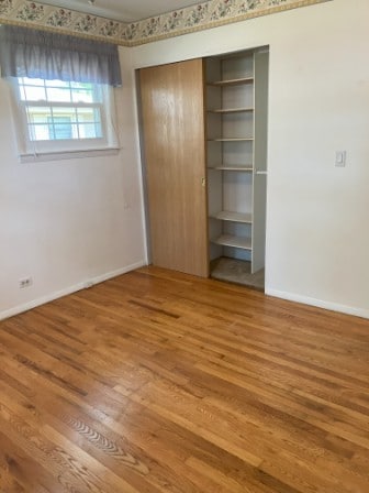 unfurnished bedroom with hardwood / wood-style flooring and a closet