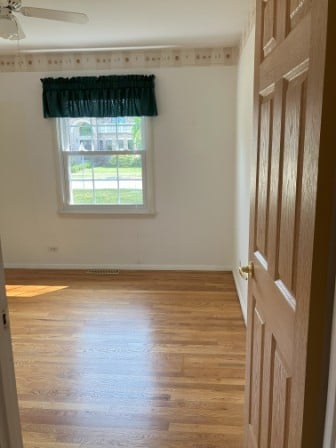 spare room with light hardwood / wood-style floors and ceiling fan