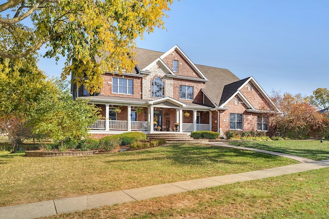 view of front of property featuring a front lawn, a porch, and brick siding