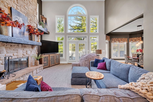 living area with plenty of natural light, carpet floors, a high ceiling, and a fireplace