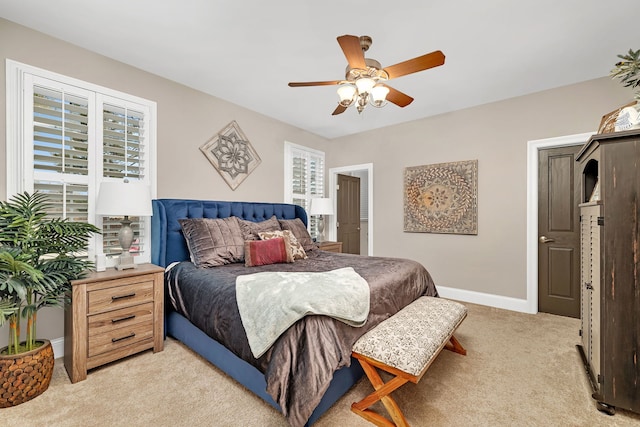 bedroom with light carpet, ceiling fan, and baseboards