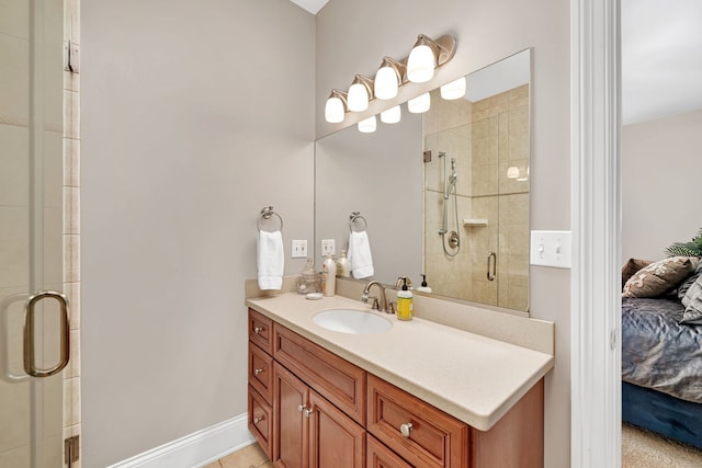 ensuite bathroom featuring a shower stall, vanity, baseboards, and ensuite bathroom