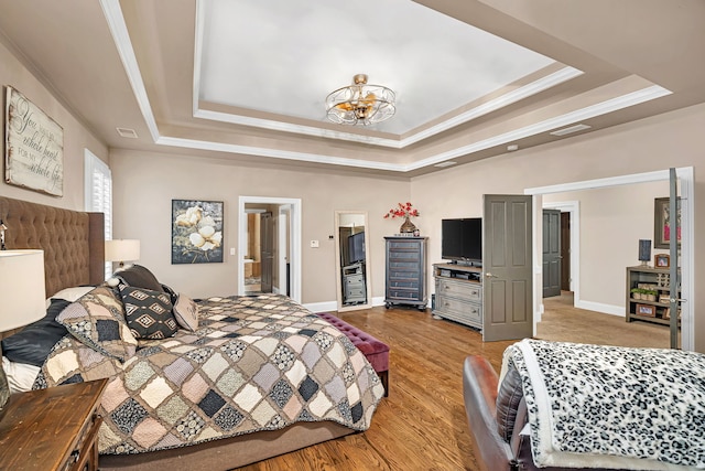 bedroom with light wood-style floors, baseboards, ornamental molding, and a raised ceiling