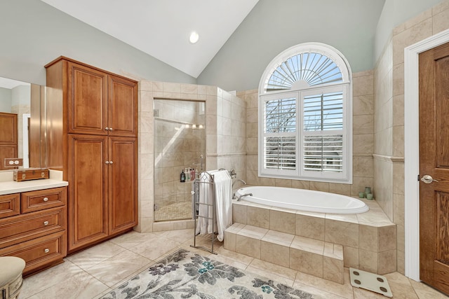 bathroom with a garden tub, vanity, vaulted ceiling, a shower stall, and tile patterned floors