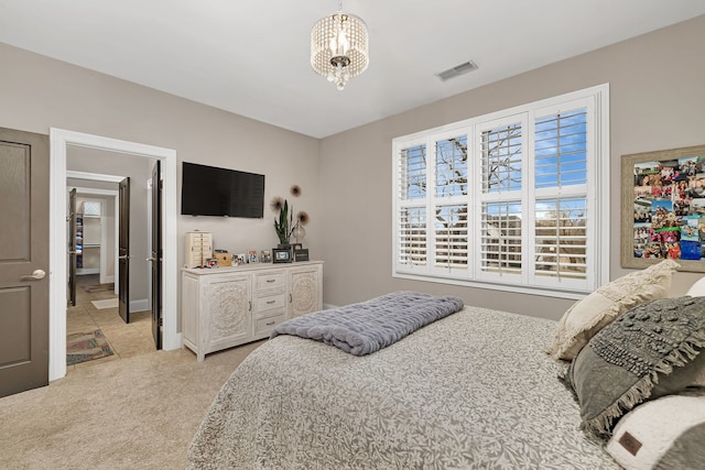 carpeted bedroom featuring visible vents and an inviting chandelier