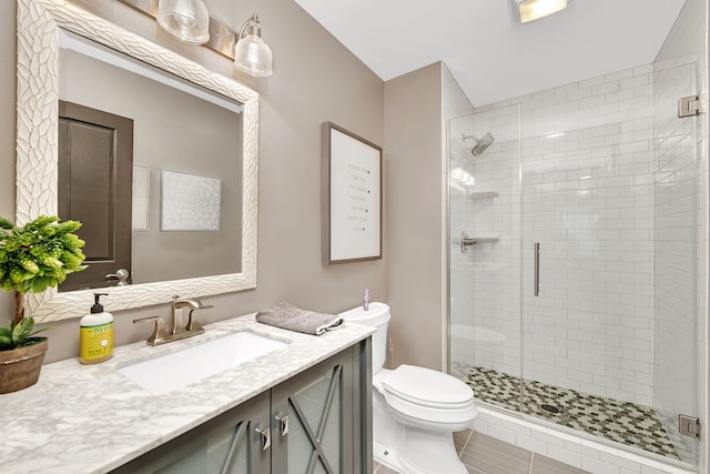 bathroom featuring a stall shower, vanity, and toilet