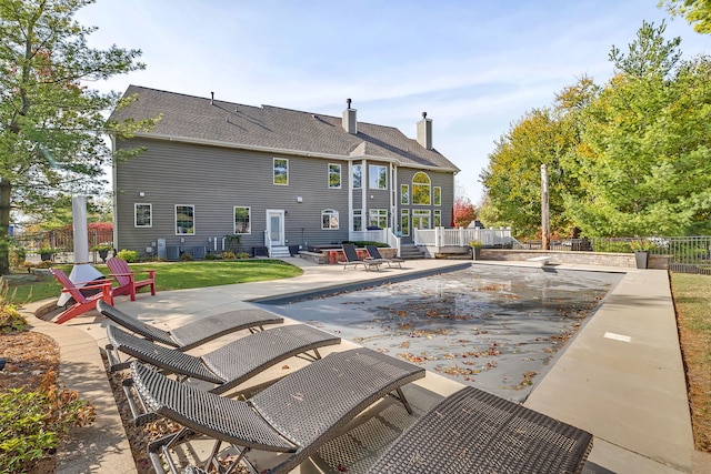 view of pool featuring entry steps, fence, and a patio