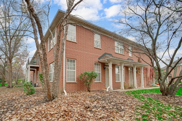 view of front facade featuring a balcony and central AC