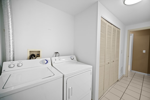 clothes washing area with washer and clothes dryer and light tile patterned floors